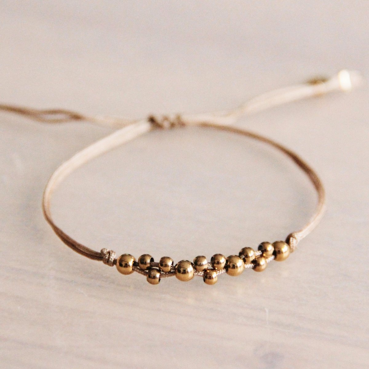 FW107 -  Satin bracelet with gold colored beads - taupe / gold